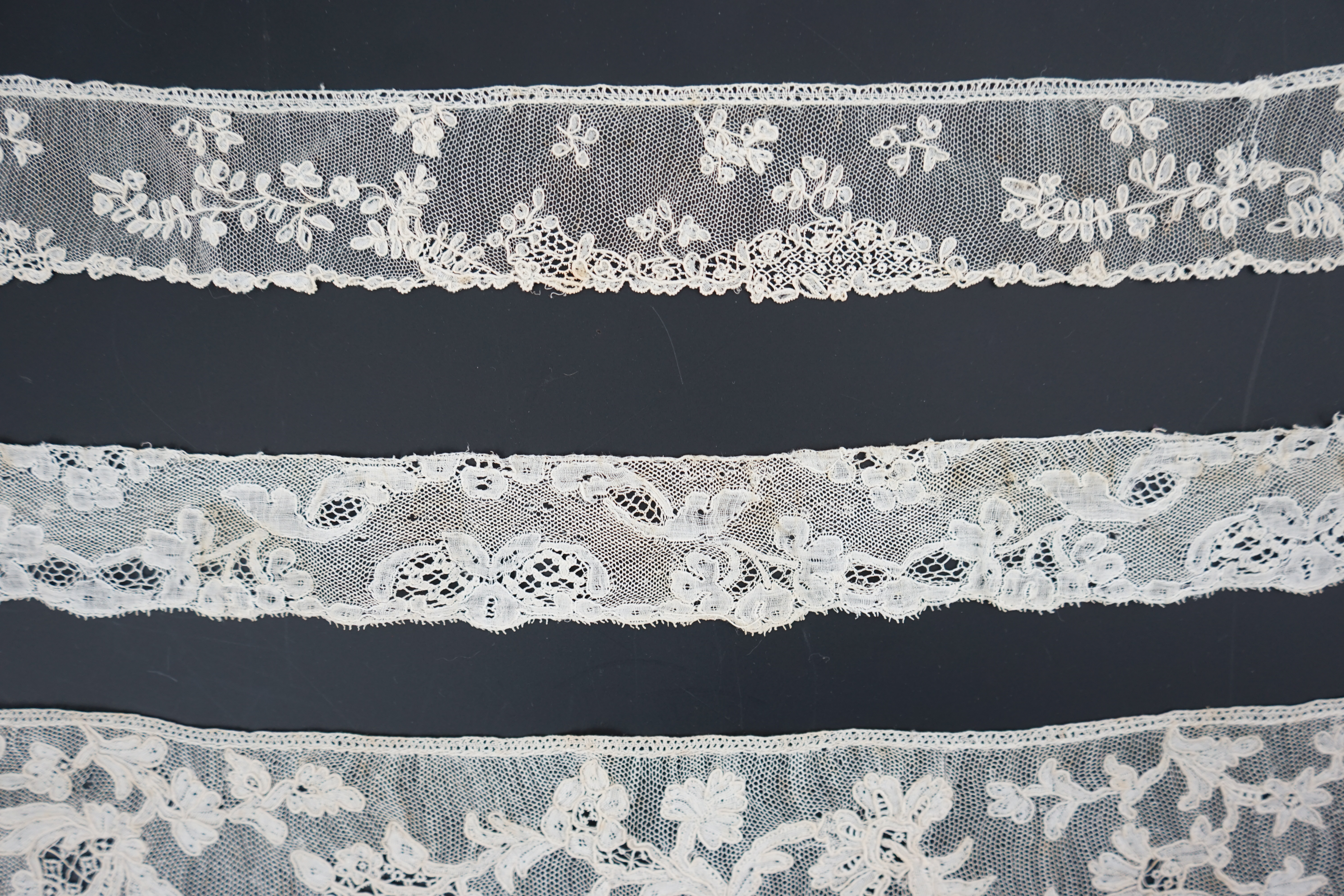 A large section of an ornate 19th century Brussels bobbin lace wedding veil, with two finished edges and one cut edge together with 18th century and later needle lace, an Argentan and an Alencon trimming, possibly an 18t